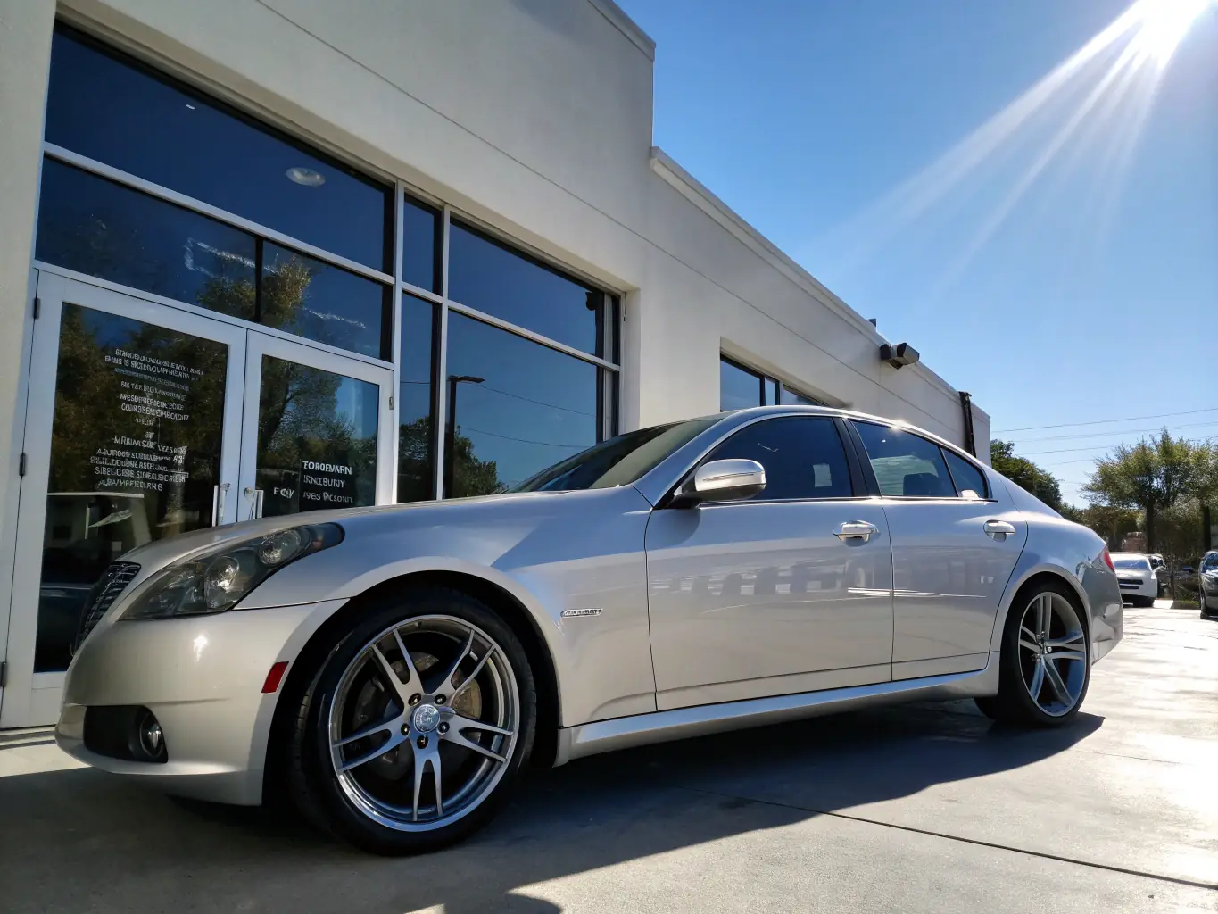 A meticulously restored luxury car in a pristine repair bay, showcasing the high standards of OEM-compliant collision repairs at Roadster Collision.